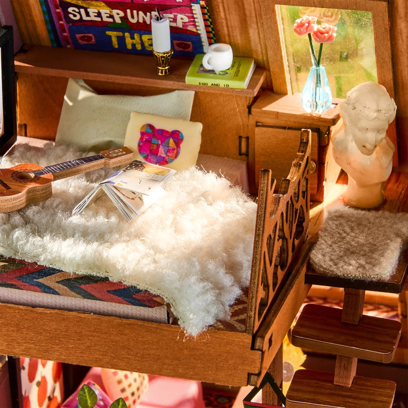 The loft with bed and decorations in the Robotime A-Frame Cabin