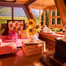 The cozy sitting area with a vase of sunflowers on the coffee table in the Robotime A-Frame Cabin
