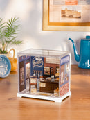 Atmospheric presentation of the Robotime Butter Bakery House, plastic miniature bakery in a small display case