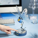 A person uses the touch button on the Robotime Butterfly (Blue) to make the wings move