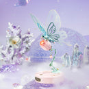 Atmospheric presentation of the Robotime Butterfly (Pink), electric construction kit of a light blue butterfly that can flap its wings, on a pink flower