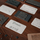 Detail of printed cards, the printing plate, and loose letters in the Robotime Classic Printing Press