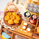 Trays of cookies, cakes, and jars of jam in Robotime Cookii Bunny’s Cookie Shop