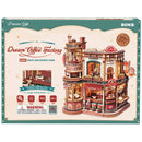 Front of package of the Robotime Dream Coffee Factory, wooden construction kit of a cozy coffee factory with lights, sounds, and moving parts where coffee is served