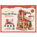 Front of package of the Robotime Dream Gift Factory, wooden construction set of a factory producing Christmas presents