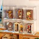 Book nooks, a wooden construction kit and a miniature house in the Robotime Dust Cover Portrait L, demonstrating that they are stackable