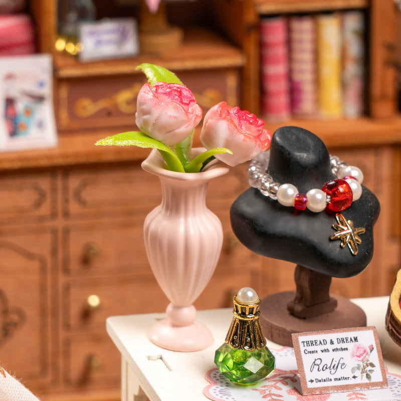 Close-up of the necklace and a vase of flowers in Robotime Elsa's Tailoring