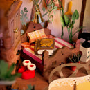 A book on the bed, a cabinet, and decorations in the Robotime Fairytale Tree House