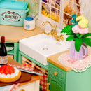 Sink in the kitchen countertop with kitchen utensils and a vase of flowers in the Robotime Farmhouse Kitchen