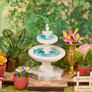 Flowers and plants in pots and vases and a fountain in the Robotime Green Fountain Garden