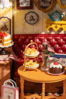 Detail of a table with some pastries and a bouquet of flowers of the Robotime Leisure Time Tea Room