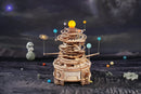 The Robotime Mechanical Orrery surrounded by decoration with a lunar landscape in the background