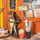 Umbrella stand, welcome sign, plant, and newspapers at the entrance of the Robotime Old Time Bookstore