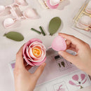 A person building the Robotime Pink Camellia