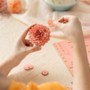 A person is crafting the Robotime Pink Dahlia flower