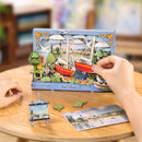 A person places one of the red sailboats in the almost completed Robotime Red Boats set