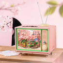 Atmospheric presentation of the Robotime Sakura Dreamy Tour, wooden construction set of a small tv with a tram car inside