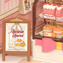 Close-up of the store sign and pastries in the display case of the Robotime Tasty Cake Shop