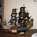 Atmospheric presentation of the Robotime Seahorse Barque, black wooden sailing ship with golden details