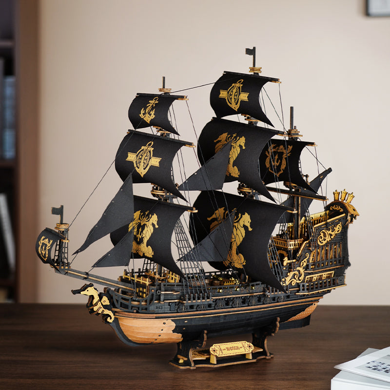 Atmospheric presentation of the Robotime Seahorse Barque, black wooden sailing ship with golden details