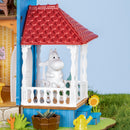Moomintroll is sitting outside on the porch of the Rolife Moominhouse